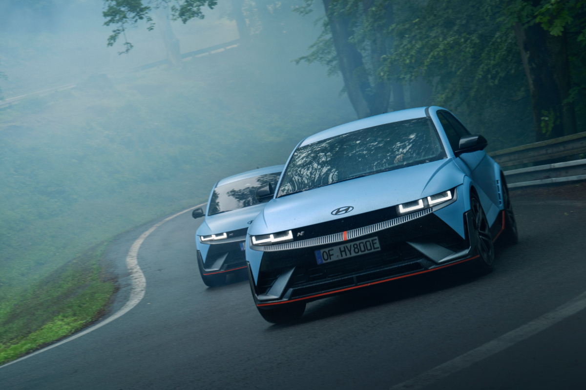 zwei blauer Hyundai IONIQ 6 N driftet sportlich über eine Rennstrecke.