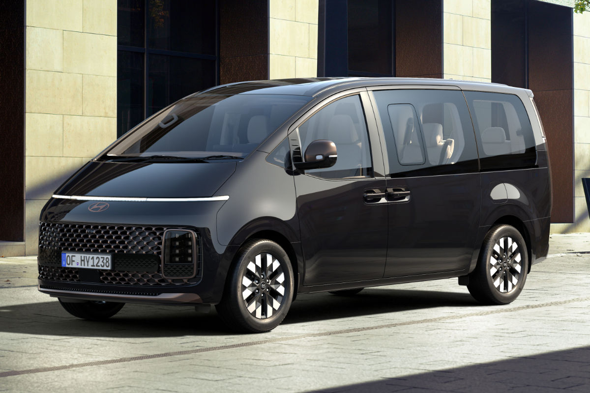 Ein grüner Hyundai Staria steht vor Gebäude